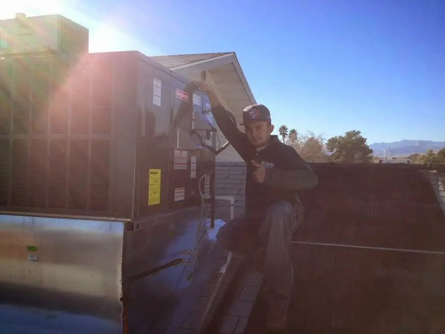 HVAC technician performing AC Tune-Up on a rooftop unit in Fort Shawnee